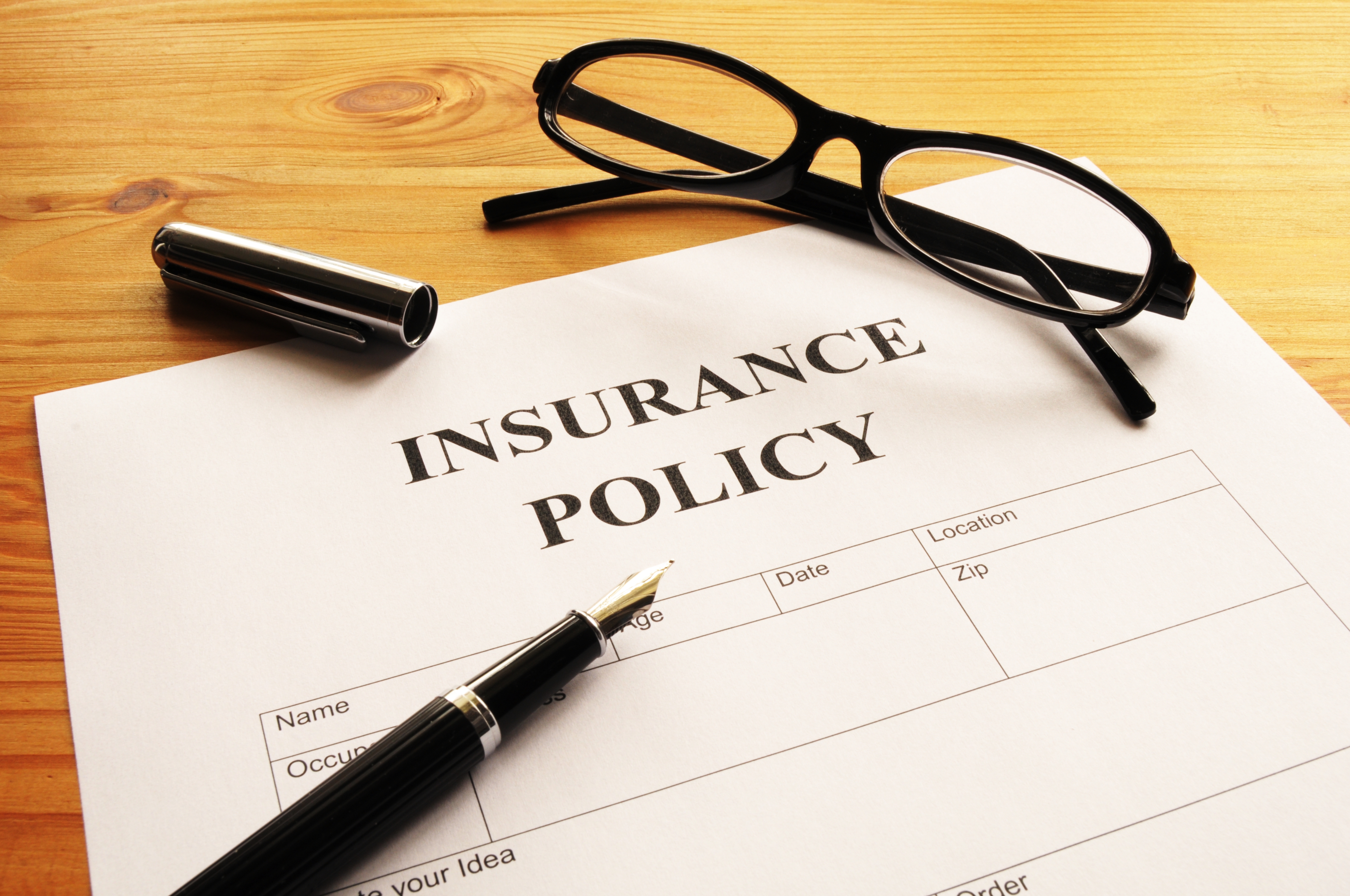 Life insurance policy with pen and a pair of reading glasses